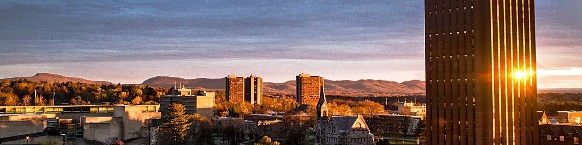 UMass Amherst campus at sunset with the Du Bois Library tower and the Holyoke Range behind it